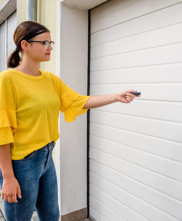 Woman presses remote to open her electric garage door